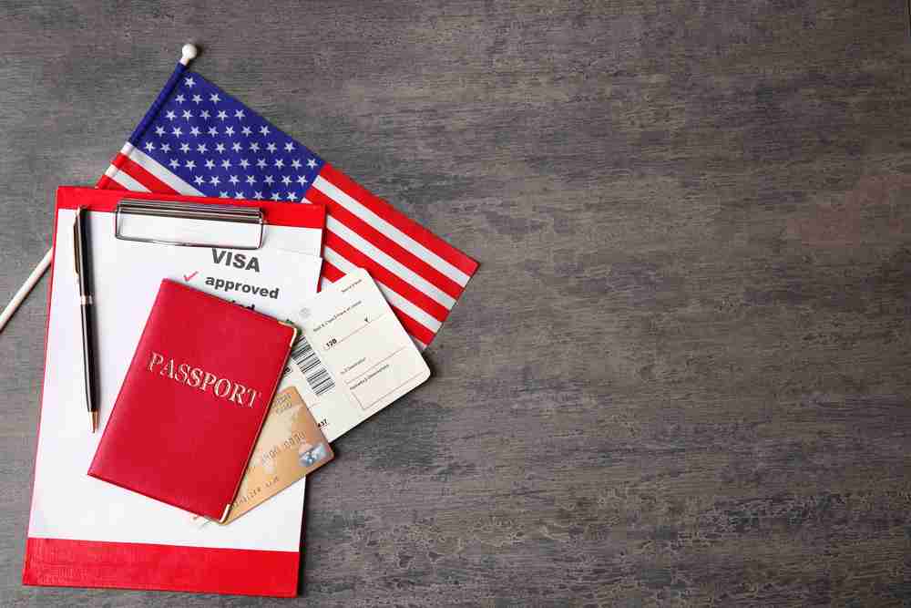passport, ticket, credit card and usa flag on table. approved american visa